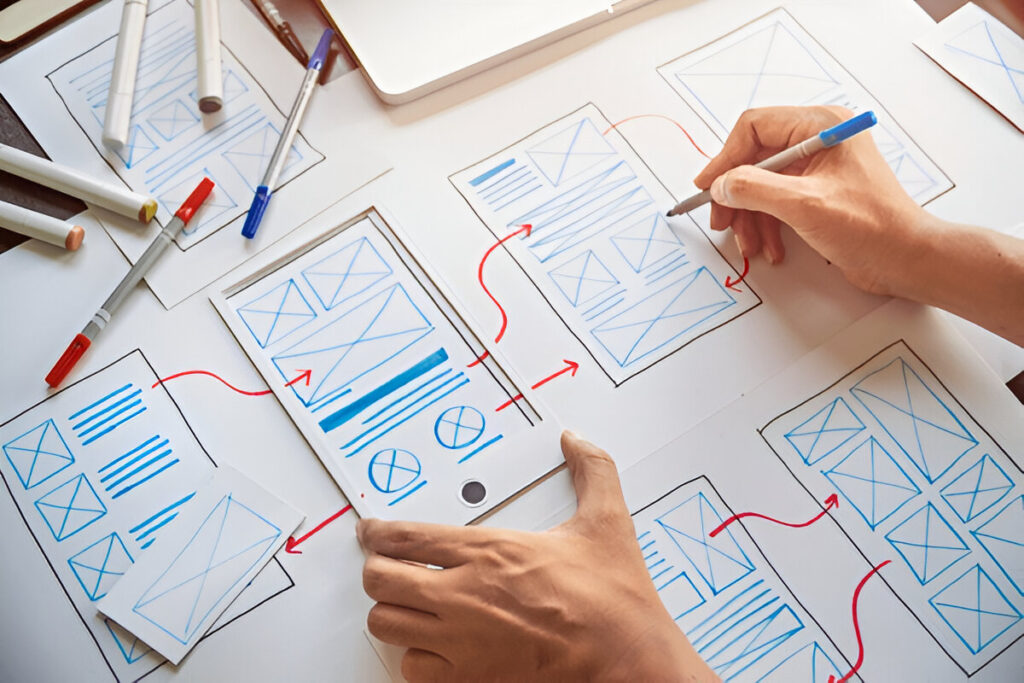 UI/UX wireframe sketches being designed on paper
