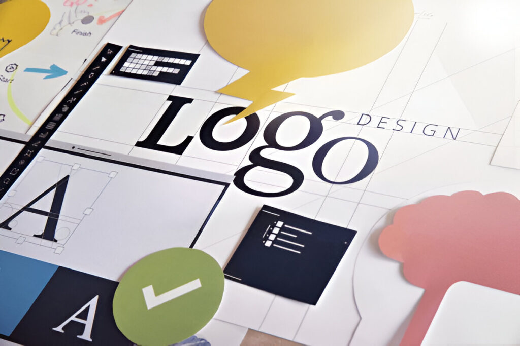 Design materials including logos, icons, and branding graphics laid out on a workspace